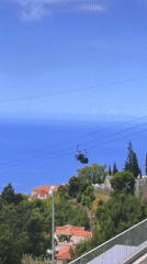 Cable car views and a balcony stop on a forested mountain