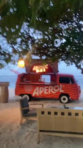 Bali beachfront at dusk: food trucks, beach gym, evening event