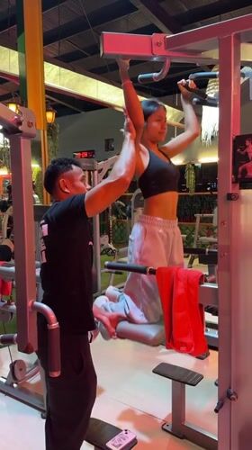 Gym workout session on a pull-up assist machine in Kuta