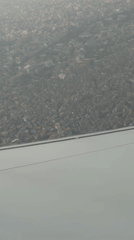 Aircraft passenger films hazy aerial view of Kathmandu cityscape