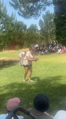 Woman conducts outdoor reptile demonstration with snake and lizard