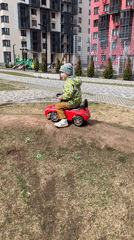 Child plays with toy car outdoors Friday morning