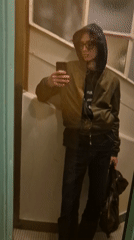 Person takes mirror selfie in olive bomber jacket in Paris