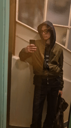 Person takes mirror selfie in olive bomber jacket in Paris