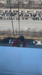 Rope-suspended worker performs building maintenance in Sankt-Peterburg