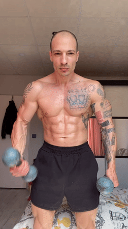 Man performs dumbbell workout on bed in Pleven bedroom