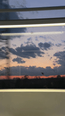Train passenger captures sunset gradient through window in Bulgaria