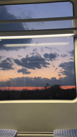 Train passenger captures sunset gradient through window in Bulgaria