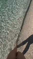 Afternoon beach stroll documented at coastal resort location