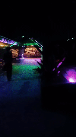 Nighttime documentation of neon-lit cafe district walkway
