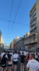 Large crowd in white shirts walks Belgrade street