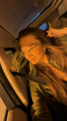 Woman smiles, winks at camera from car in Tavros