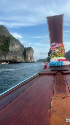 Decorated wooden boat cruising past limestone karsts off Ao Nang