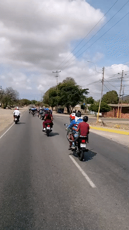 Cycling group travels road near San Juan Bautista, Venezuela