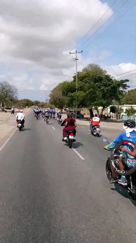 Cycling group travels road near San Juan Bautista, Venezuela