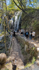 Visitors walk crowded path near waterfall at Plitvice Lakes
