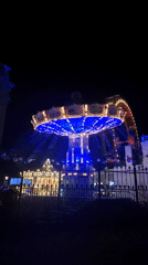 Swing ride glowing at a Vienna amusement park after dark
