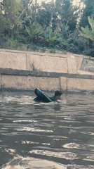 Children swim in canal amid blooming flowers in Saweuk