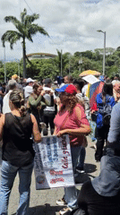 Democracy protesters gather in Caracas park with political signs