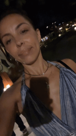 Woman films nighttime walk through illuminated Indonesian resort area