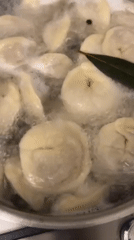 Home cook prepares dumplings while video calling in Italy