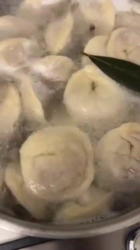 Home cook prepares dumplings while video calling in Italy