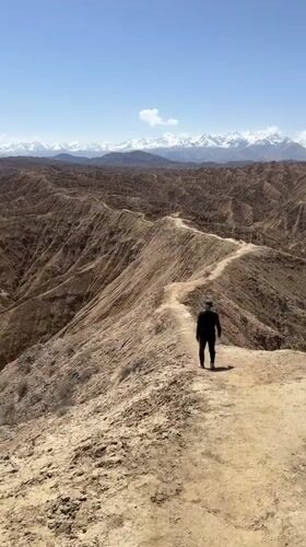 Solitary hiker spotted on ridge trail in Kyrgyzstan mountains