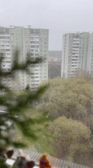 Spring snow falls on Moscow residential buildings amid budding trees
