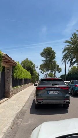 A video from a car's perspective showcases the back of an SUV with the text "EBRO S800" on the back as it drives slowly through a sunny, tree-lined residential area. A cyclist quickly passes on the road. The video ends with a view of a street lamp.