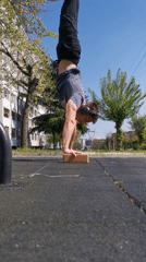 Man performs handstand on wooden block in Burgas park
