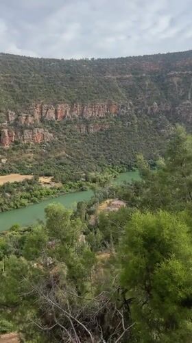 Visitor documents Bin El Ouidane Dam amid Moroccan mountain landscape