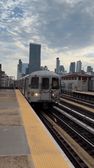NYC train arrives at an urban station platform
