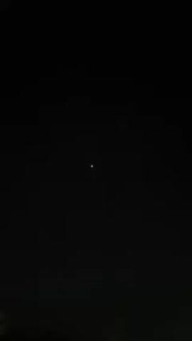 The video shows a dark night sky. A single bright point of light, possibly a star or planet, is visible in the center of the frame. Another much fainter point of light appears lower and to the right. The camera is held still.