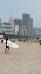 Overcast morning at Đà Nẵng beach, surfers, resorts, and shoreline life