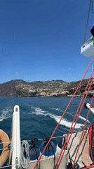 Sailboat with two people navigates choppy waters off Madeira