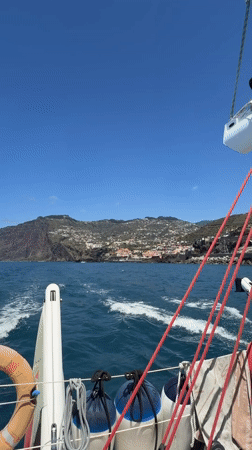 Sailboat with two people navigates choppy waters off Madeira
