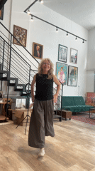 Woman dances in eclectic Tel-Aviv apartment with art, plants