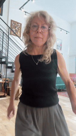 Woman dances in eclectic Tel-Aviv apartment with art, plants