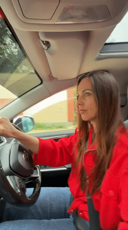 Woman in red jacket photographed with car in Birobidzhan