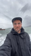 Tourist documents stormy seas at Montenegro beach