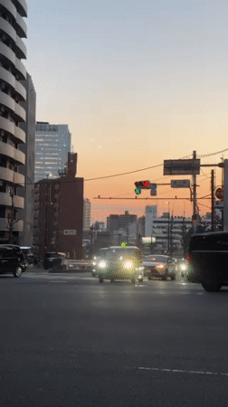 Evening traffic flows through Shibuya crosswalk at dusk