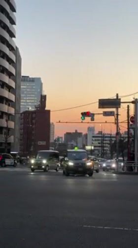 Evening traffic flows through Shibuya crosswalk at dusk