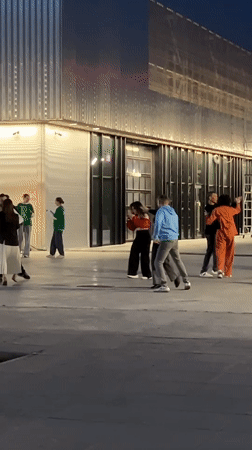 Evening social gathering observed near illuminated bridge in Kazan