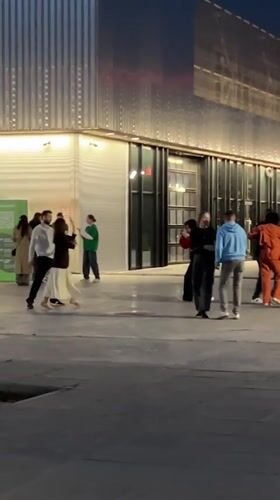 Evening social gathering observed near illuminated bridge in Kazan