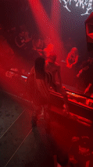 Milan nightclub scene captured with dancing, purple lights, digital displays