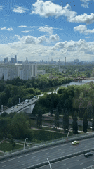 Helicopter carries container over Khimki cityscape in morning operation