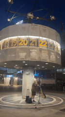 Street performer sings with Ukrainian flag at Berlin World Clock