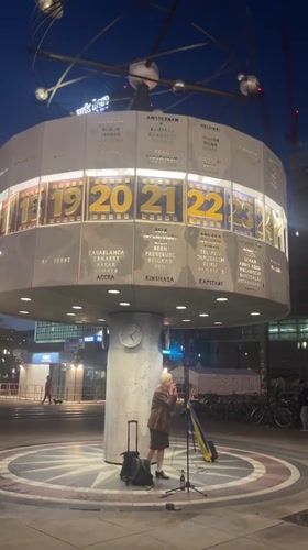Street performer sings with Ukrainian flag at Berlin World Clock