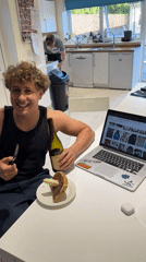 Man photographed at kitchen table with knife, wine bottle