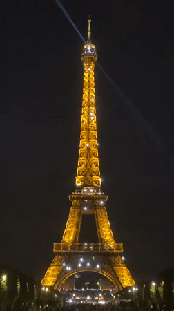 Eiffel Tower sparkles with golden lights in Paris evening